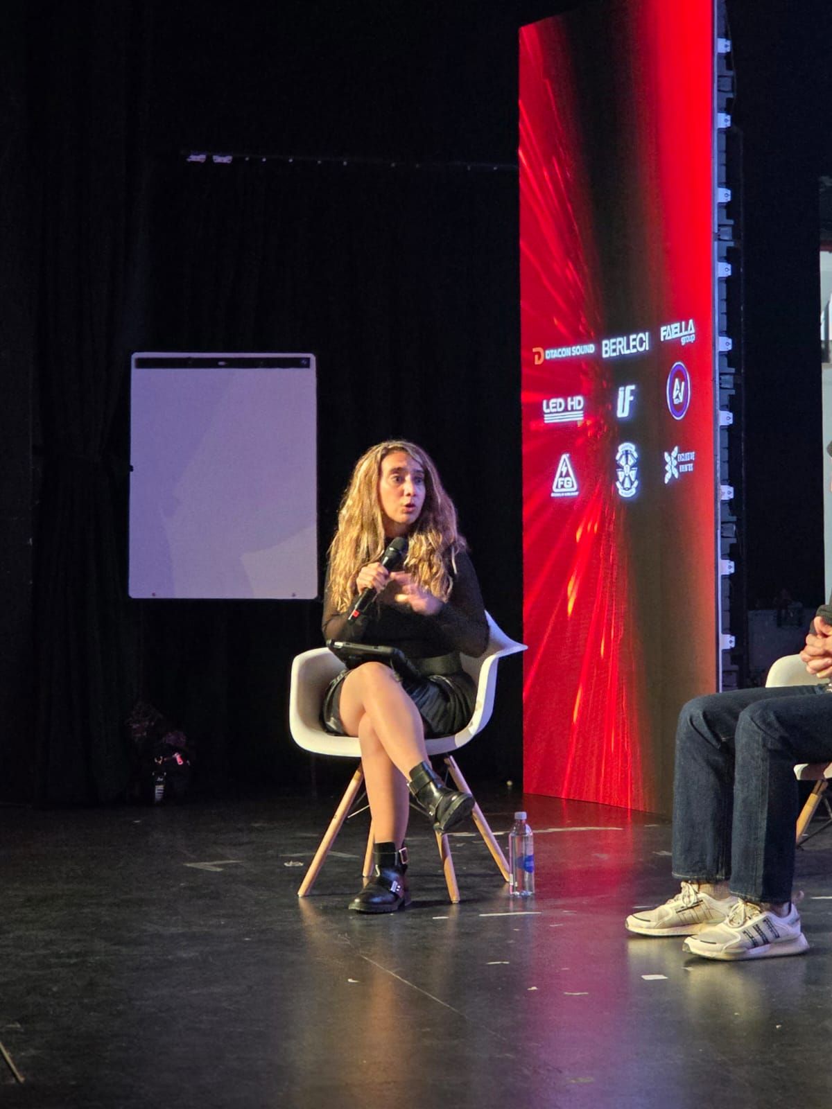 Conversatorio en el escenario del Summit entre la moderadora y su invitado