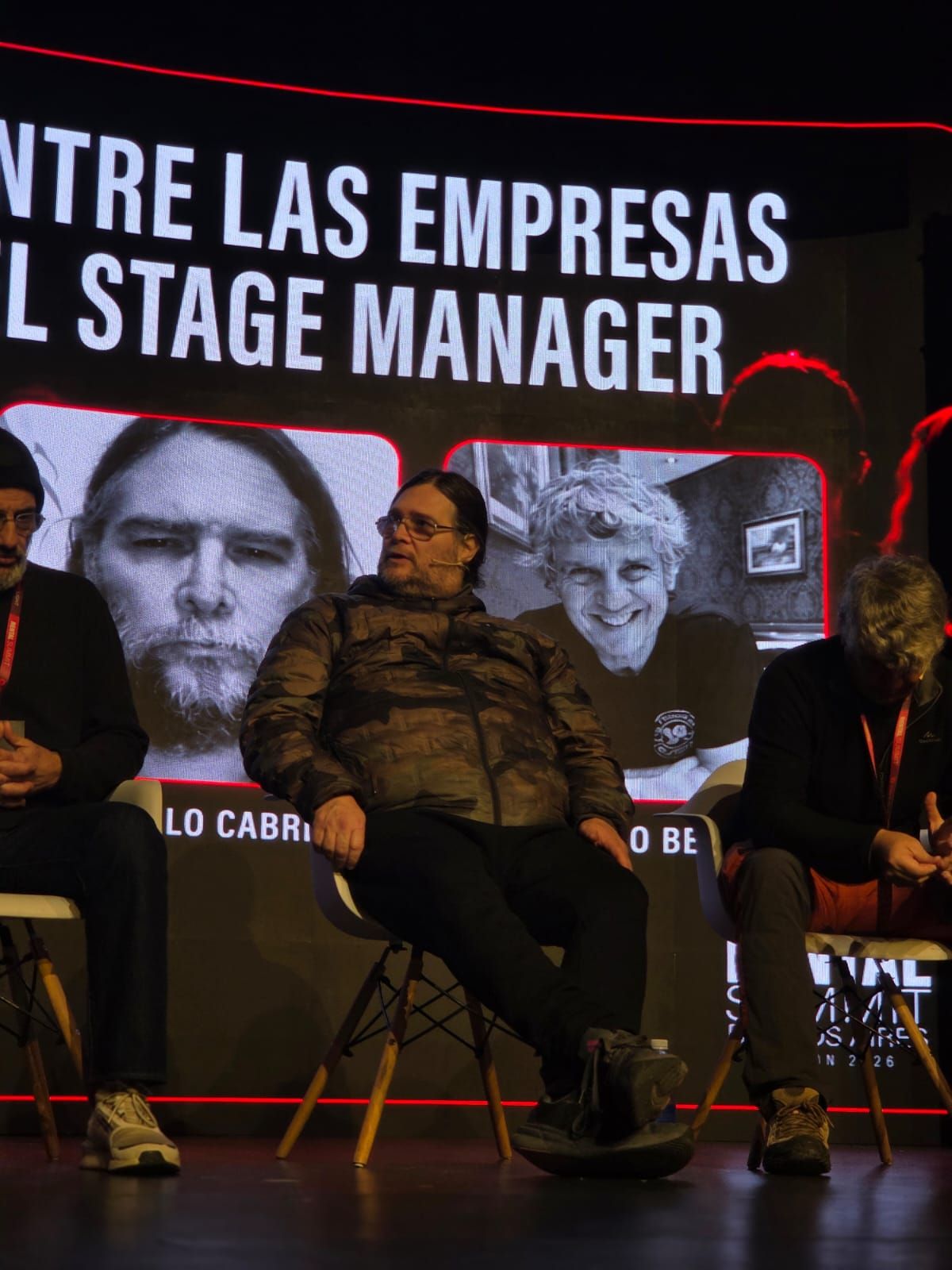Panel de Stage Managers en el escenario, con el título de la charla y los retratos de los panelistas en el LED